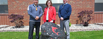 From left, St. Louis High School Principal Ben Brock, MCC English Instructor Erin Busch-Grabmeyer and MCC Dual Enrollment English Instructor/Coordinator Ben Stancil pose for a photo behind the rock outside the entrance of St. Louis High School.
