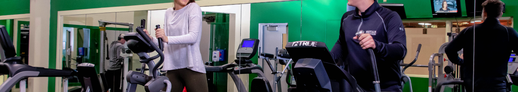 Male and female students walking on indoor treadmills