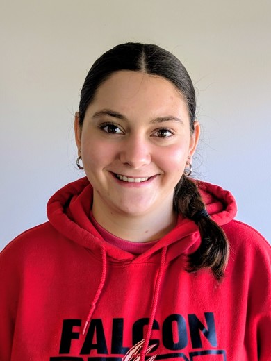Headshot of Aimee Friesen wearing a red sweatshirt and silver hoop earrings.