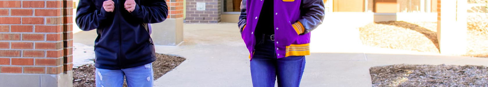 two students walking outside of a brick building