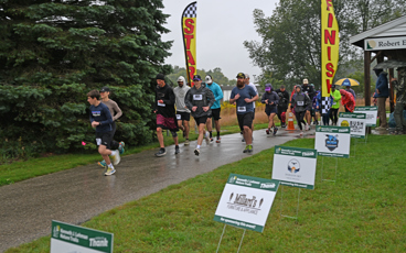 Participants running in 11th annual Bramble Ramble amidst rainy conditions. 
