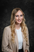 Headshot of Trista Visner wearing a tan blazer with a white shirt underneath. She has long blond hair and blue eyes.