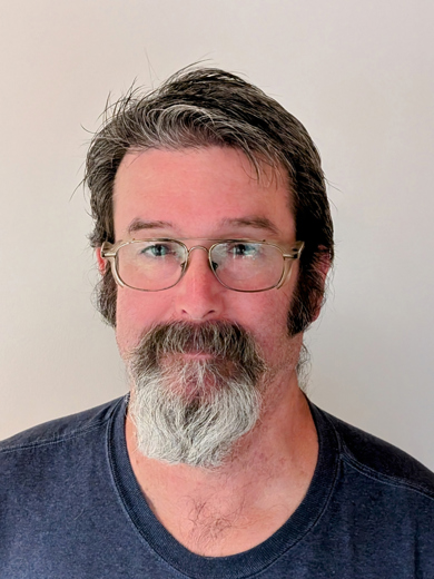 Headshot of David Pitts wearing glasses and a navy blue tshirt.