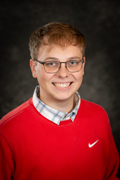 Headshot of Alex Gorby wearing a red sweatshirt with a buttondown shirt underneath.