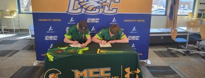 Two future student-athletes signing their letter of intent with MCC Clay Target team.