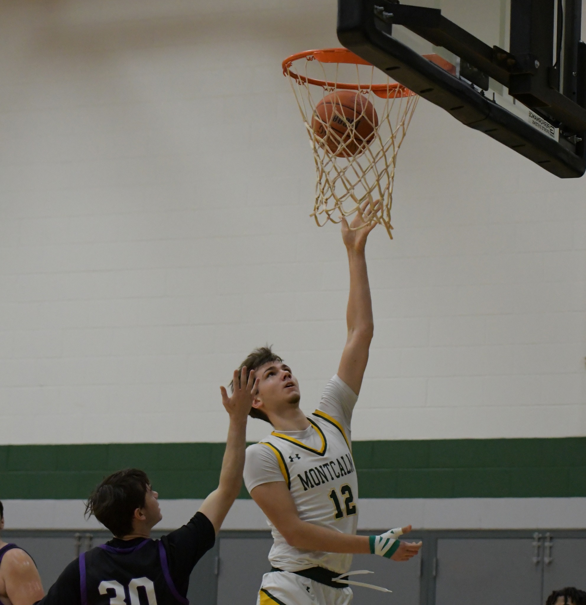 Men's basketball player going up to shoot a layup. 