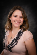 Professional photo of Celina Flegal wearing a light pink shirt with black lace ruffles.