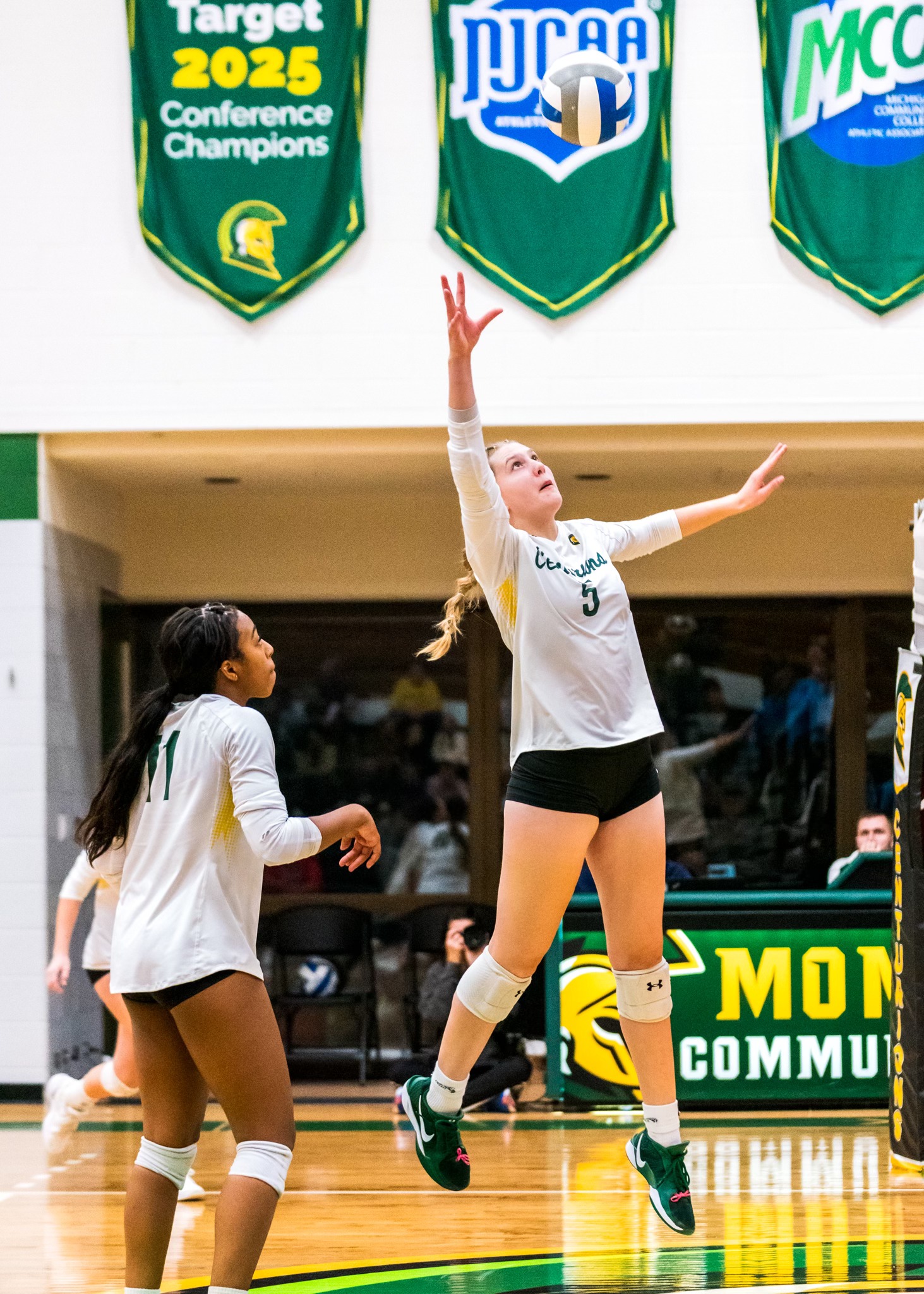 MCC Volleyball player jumps to hit the ball coming over the net.