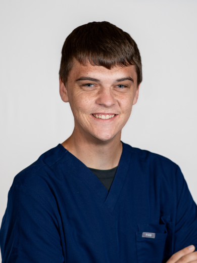 Headshot of Chase Taylor wearing blue scrubs.