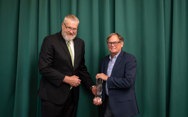 Board Chair Kurt Peterson handing Dr. Kirk Faber the Distinguished Service Award at the Centurion Award Banquet.