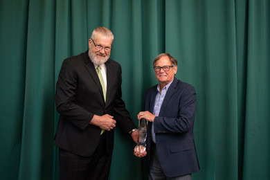 Board Chair Kurt Peterson handing Dr. Kirk Faber the Distinguished Service Award at the Centurion Award Banquet.