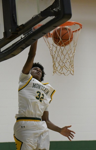 MCC men's basketball player dunking the ball during a game. His uniform number is 32.