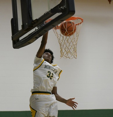 MCC men's basketball player dunking the ball during a game. His uniform number is 32.