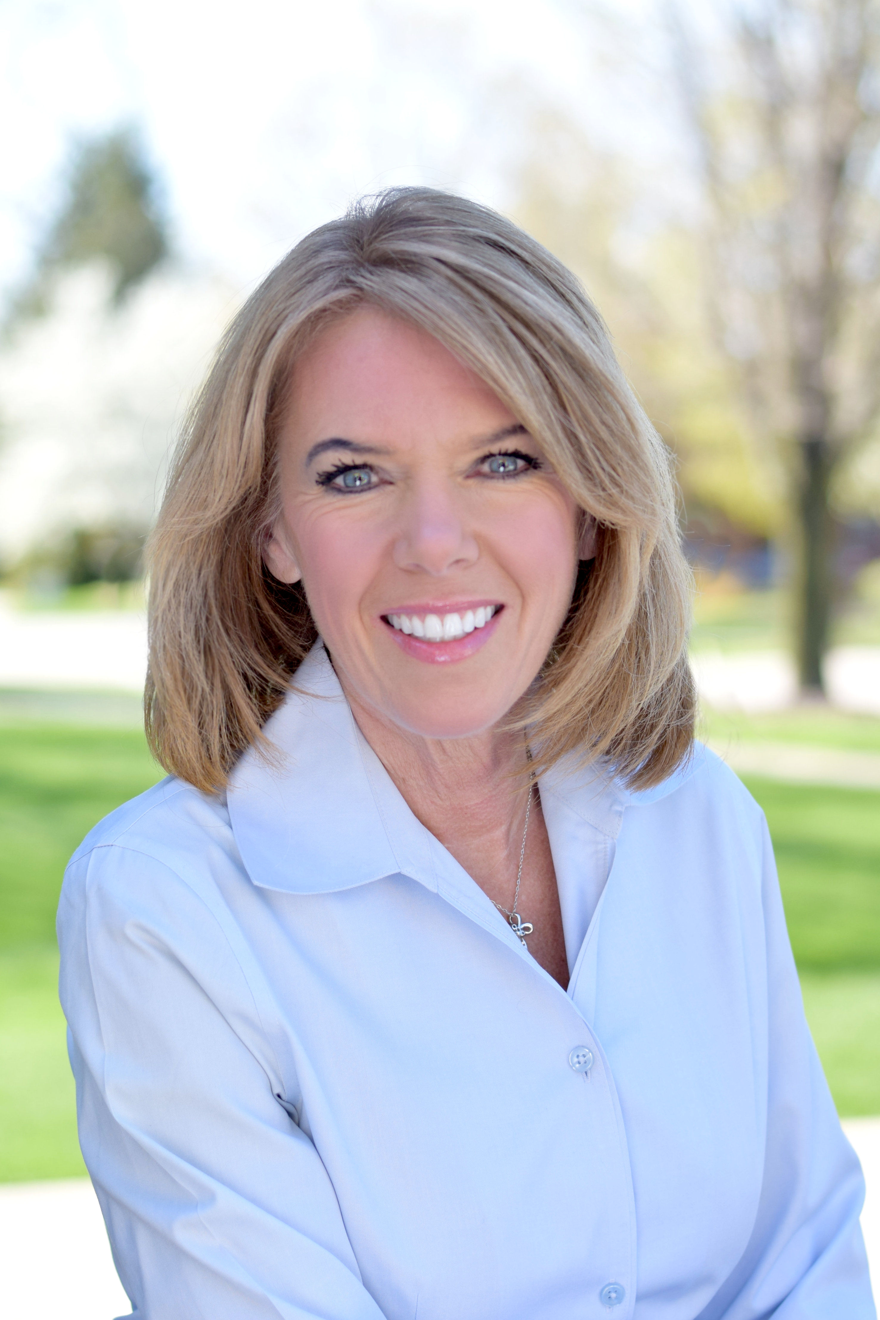 Headshot of meteorologist Terri DeBoer wearing a white button down shirt with blue eyes and sandy blond hair.