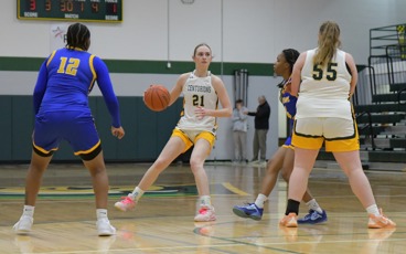 MCC women's basketball player Emma Rehkopf dribbles the ball on the home court during a game with opposing players an teammates surronding her.