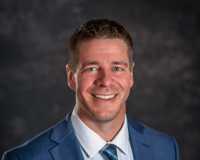 Professional headshot of Vice President of Academic Affairs Kevin Wagenmaker in blue suit smiling at the camera.