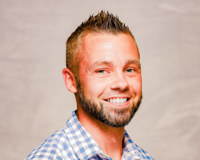 Headshot of Bob Byram smiling and wearing a blue and white checked shirt.