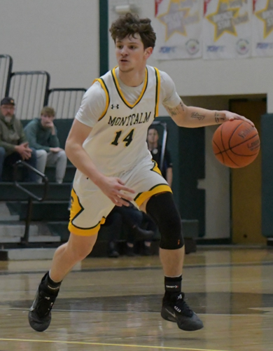 MCC men's basketball player Trevor Zammaron dribbling the ball on the court. 