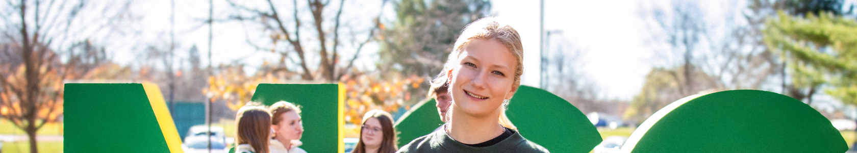Students smiling in front of MCC letters.